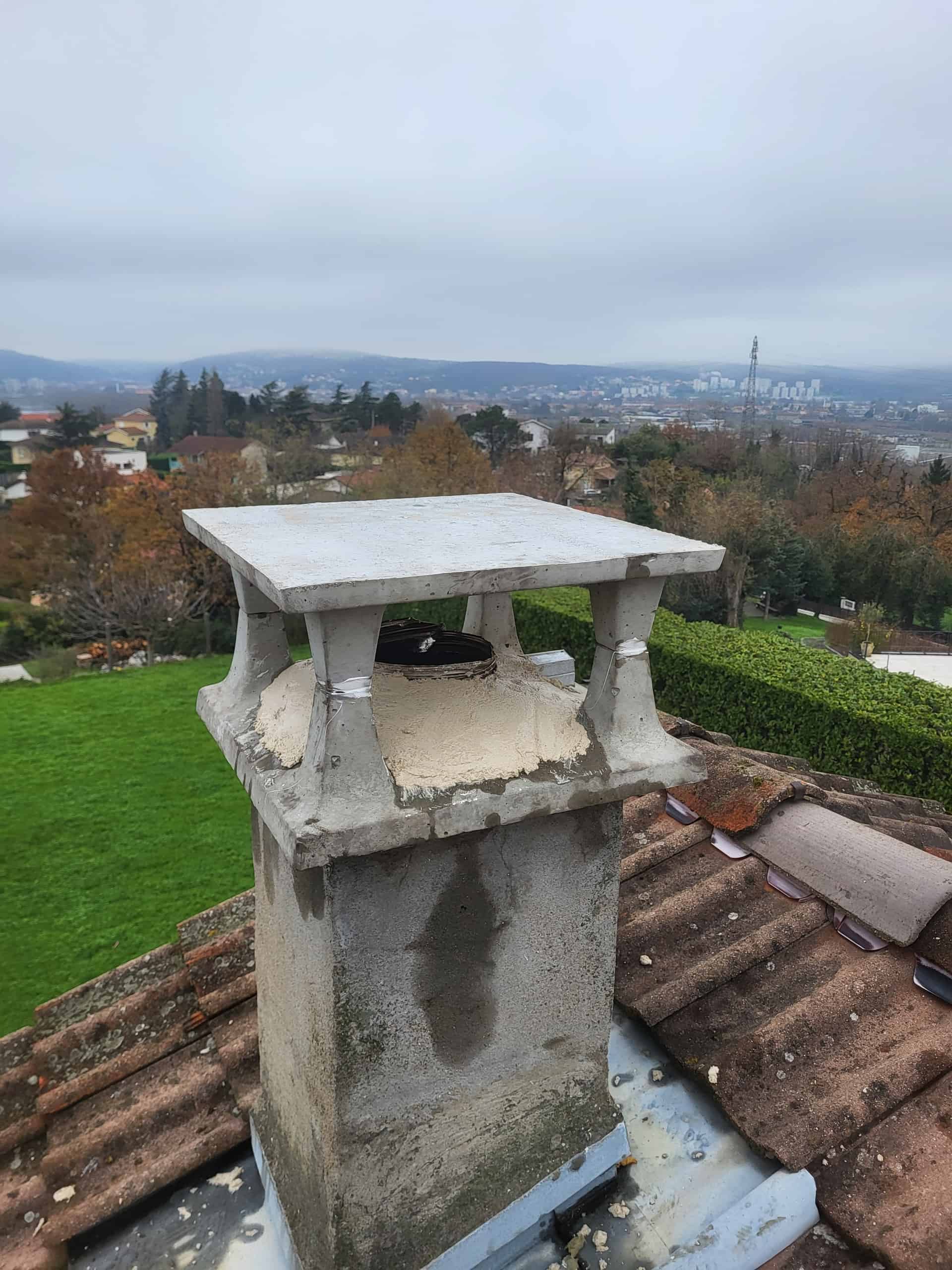 Cheminée à Vienne avec chapeau neuf posé par un ramoneur professionnel pour éviter les infiltrations d'eau. Vue panoramique sur la ville en arrière-plan depuis le toit
