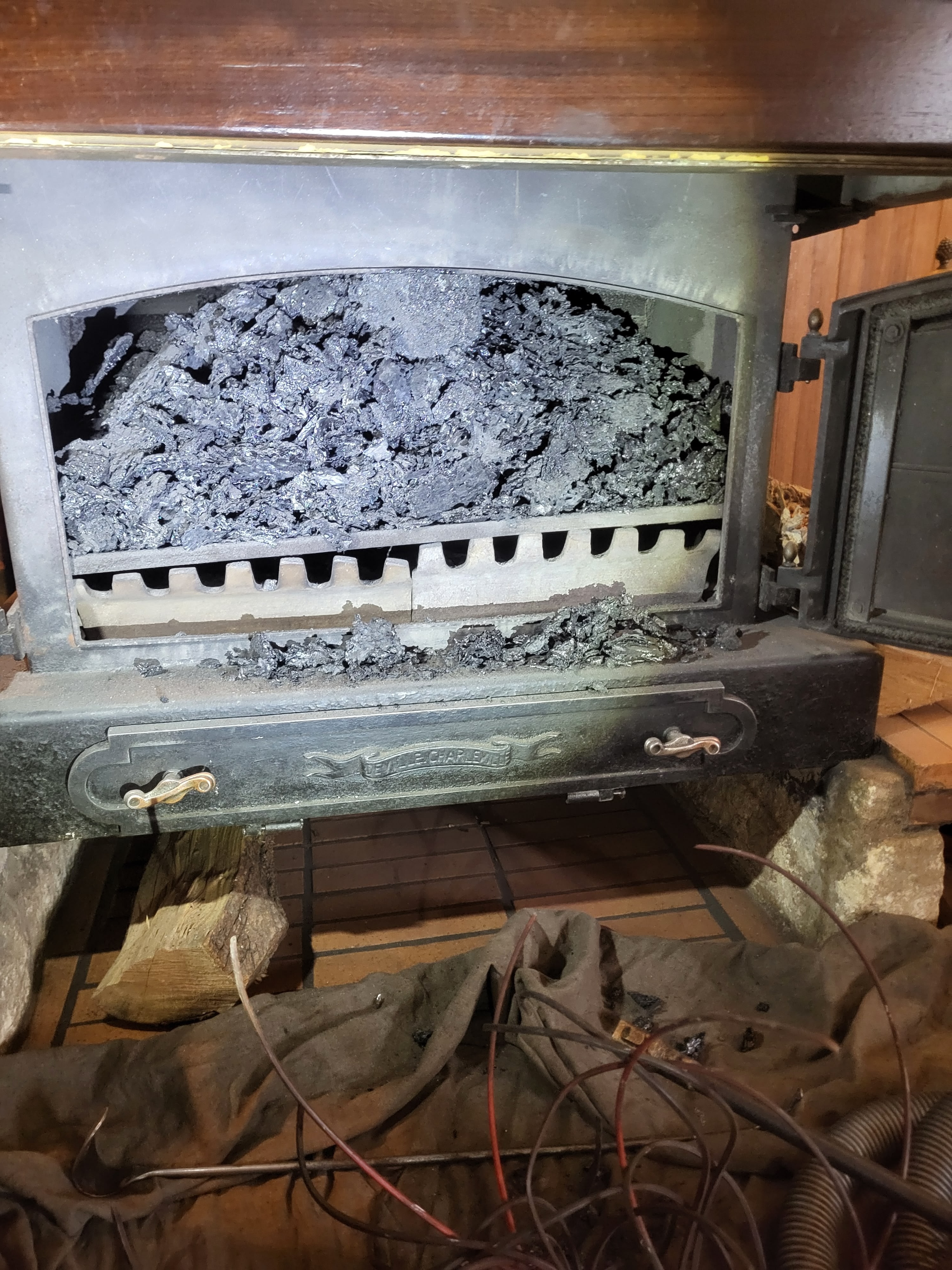 Intérieur d'un foyer ouvert montrant l'accumulation de cendres et de résidus nécessitant un ramonage professionnel à Vienne